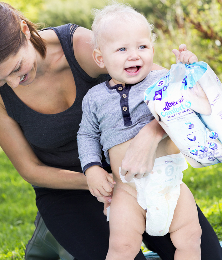 Woman changes a baby's diaper (photo)