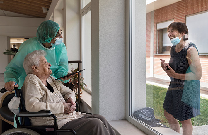 Old woman in a wheelchair laughing with her daughter (photo)