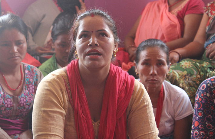 Woman sitting in front of many other women (photo)