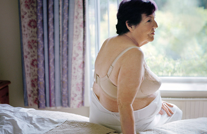 Woman sitting on a bed (photo)