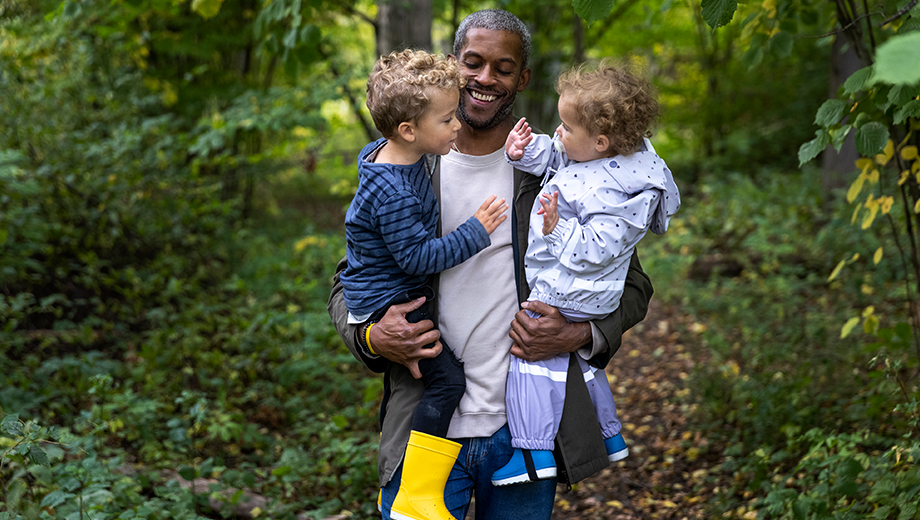 Man walking around with kids on his arms