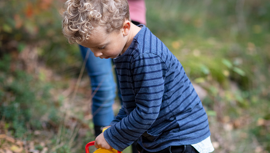 Kid pouring water out of a watering pot